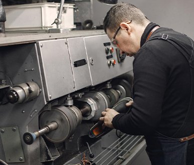 Flyzone technician operating a lathe machine for precision machining services.